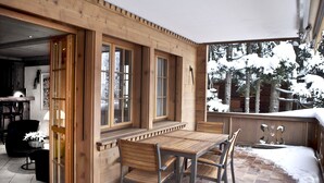 En matplats inredd med trä, komplett med bord och stolar, stora fönster och utsikt över snötäckta träd.