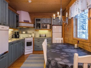 Una cocina acogedora con armarios de madera, estufa, microondas y refrigerador.