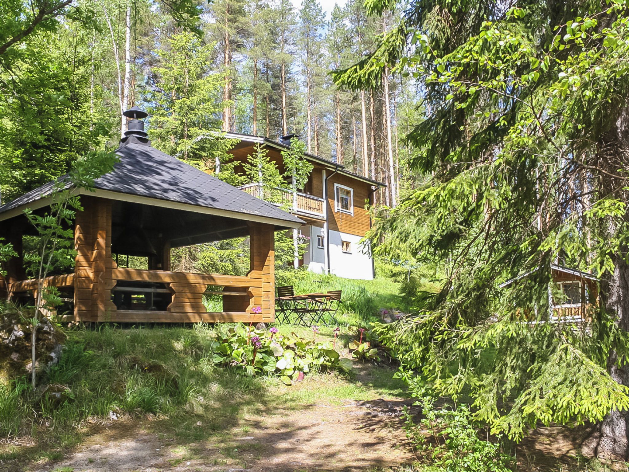 Une cabane avec une façade en bois, une véranda et une terrasse.