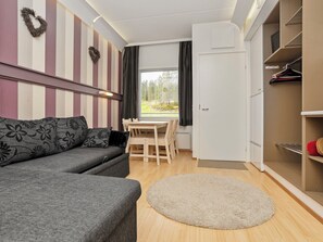 A compact living space with a sofa, a dining table, and a wardrobe.