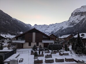 A mountain lodge with a large building, snow-covered landscape, and surrounding trees.