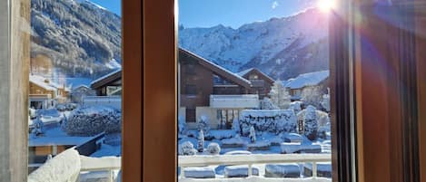A snowy mountain landscape with buildings and a clear sky.