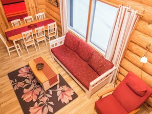 A cozy cabin interior with a sofa, chairs, a dining table, and a window with curtains. - Rukan lepolinna b by Interhome (Kuusamo)