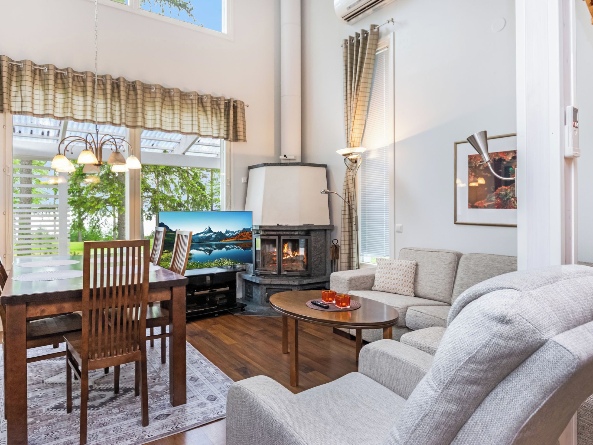 A cozy living room with a fireplace, a dining area with a table and chairs, and a sofa.