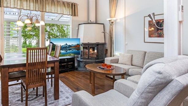 Una sala de estar acogedora con chimenea, un comedor con mesa y sillas, y un sofá.