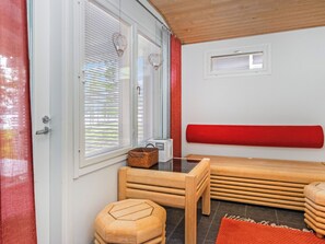 A room with a wooden bench, a small table, a basket, and a window with blinds. - Paltamon golfhovi b by Interhome (Paltamo)