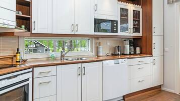 A modern kitchen with white cabinetry, a built-in oven, and a dishwasher.