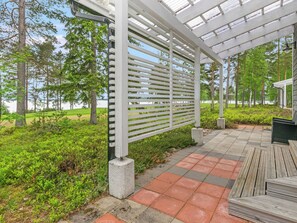 A covered outdoor area with a pergola, a paved walkway, and a view of a lake. - Paltamon golfhovi b by Interhome (Paltamo)