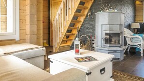 A cozy room with a fireplace, wooden staircase, and a comfortable seating area. - Villa vuosku by Interhome (Enontekiö)