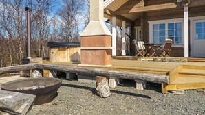 A wooden deck with a fire pit, outdoor seating, and a chimney. - Villa vuosku by Interhome (Enontekiö)
