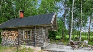 A log cabin with a stone foundation, a wooden deck, and outdoor seating. - Meritähti by Interhome (Pöytyä)