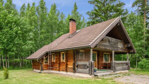 A wooden cabin with a porch, a chimney, and a grassy yard surrounded by trees. - Meritähti by Interhome (Pöytyä)