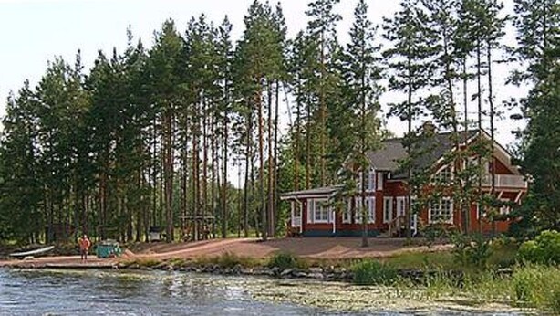 A house by a river with a dock, surrounded by tall trees. - Pernoo 3 by Interhome (Kotka)