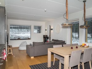 A modern living room with a grey sofa, wooden dining table, and large windows with snowy views. - Levi hillside by Interhome (Kittilä)