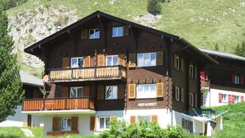 Un immeuble en bois à plusieurs étages, doté de balcons et d’une enseigne sur laquelle on peut lire « ABENDROT ».
