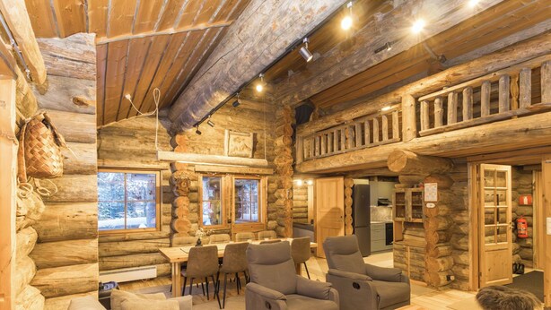 A log cabin interior with a dining area, sofas, and a kitchen. - Rukasaukko by Interhome (Kuusamo)