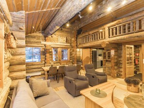 A log cabin interior with a dining area, sofas, and a kitchen. - Rukasaukko by Interhome (Kuusamo)