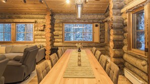 A log cabin interior with a long dining table, a sofa, and a fireplace. - Rukasaukko by Interhome (Kuusamo)
