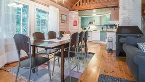 Un acogedor interior de cabaña con comedor, cocina y sala de estar.