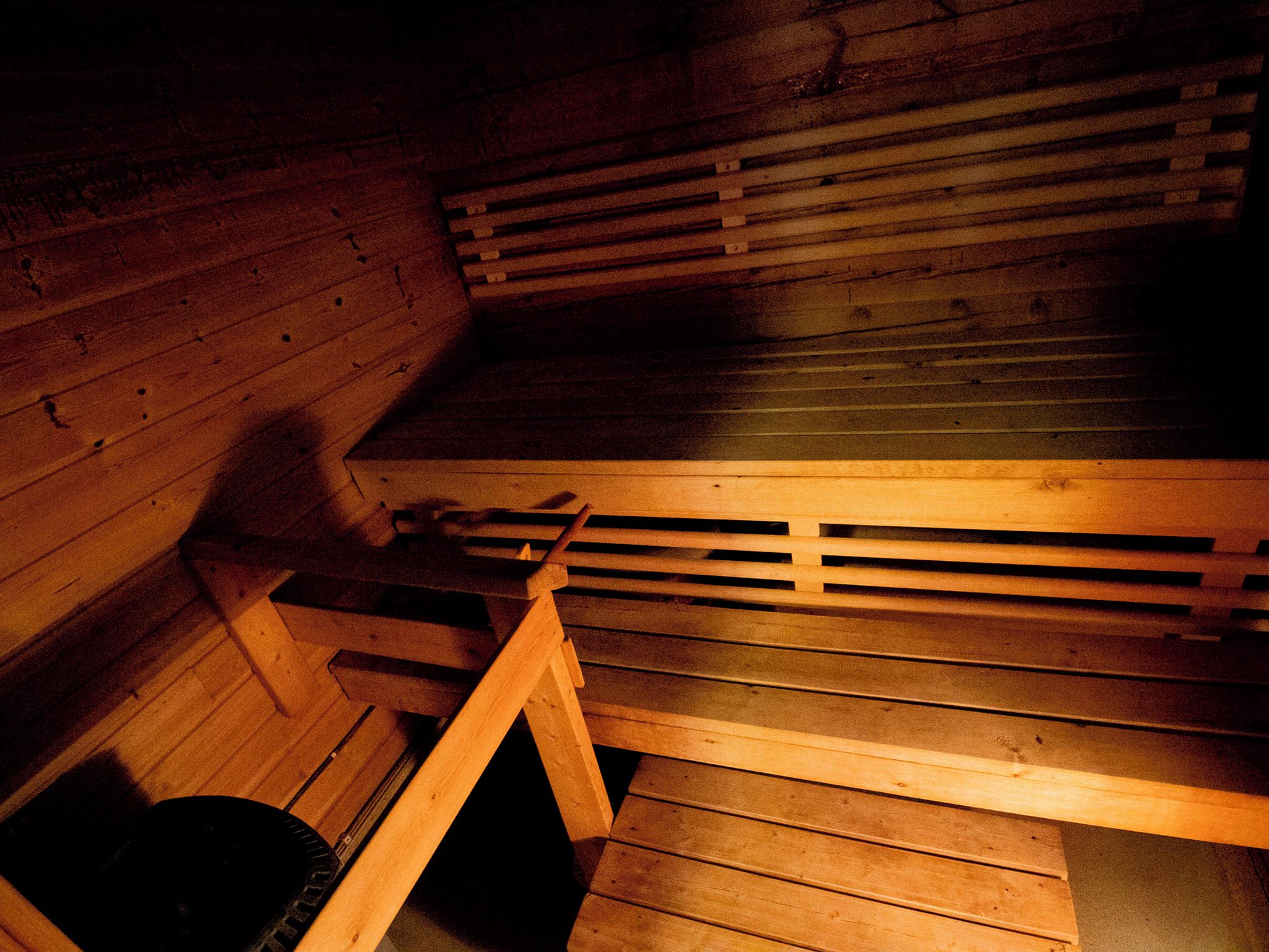 Een sauna met houten banken en een schuin dak.