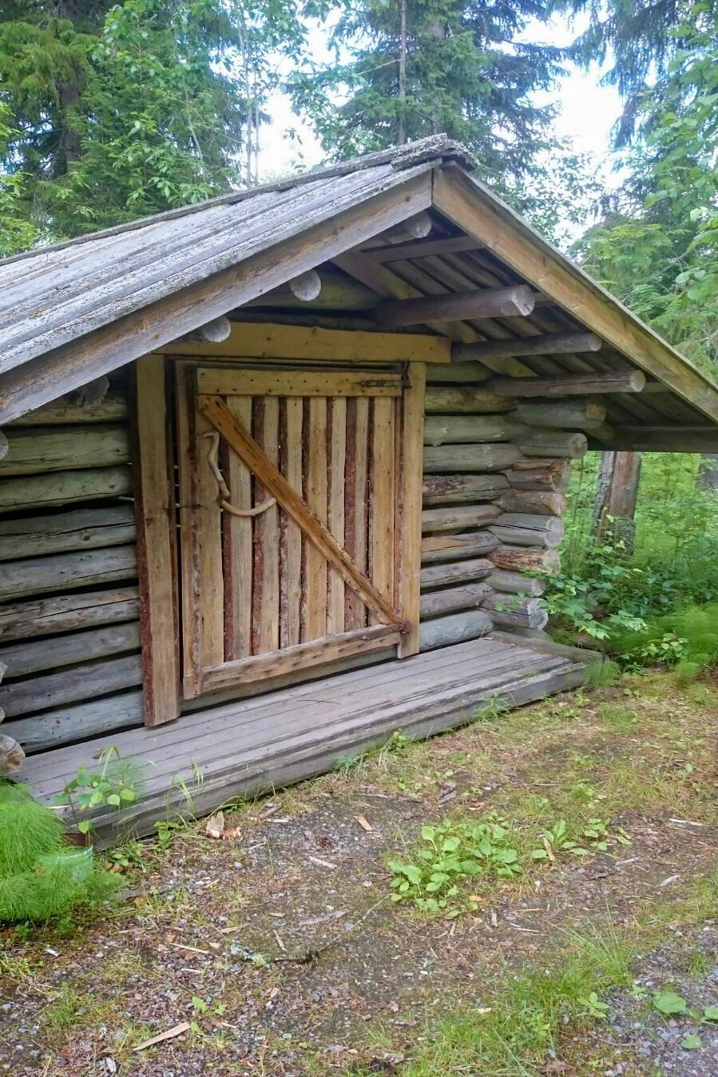 A rustic log cabin with a wooden door and a simple porch.