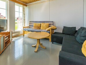 A living room with a sofa, a round table, and a television. - Kylämattila by Interhome (Loimaa)