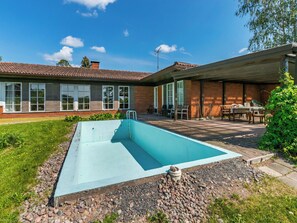 A residential property with a swimming pool, a patio area with outdoor furniture, and a brick house. - Kylämattila by Interhome (Loimaa)
