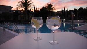 Two glasses of a clear beverage with ice cubes on a white table by a pool. - Rescator Resort 224 - One Bedroom Resort, Sleeps 4 (Roses)