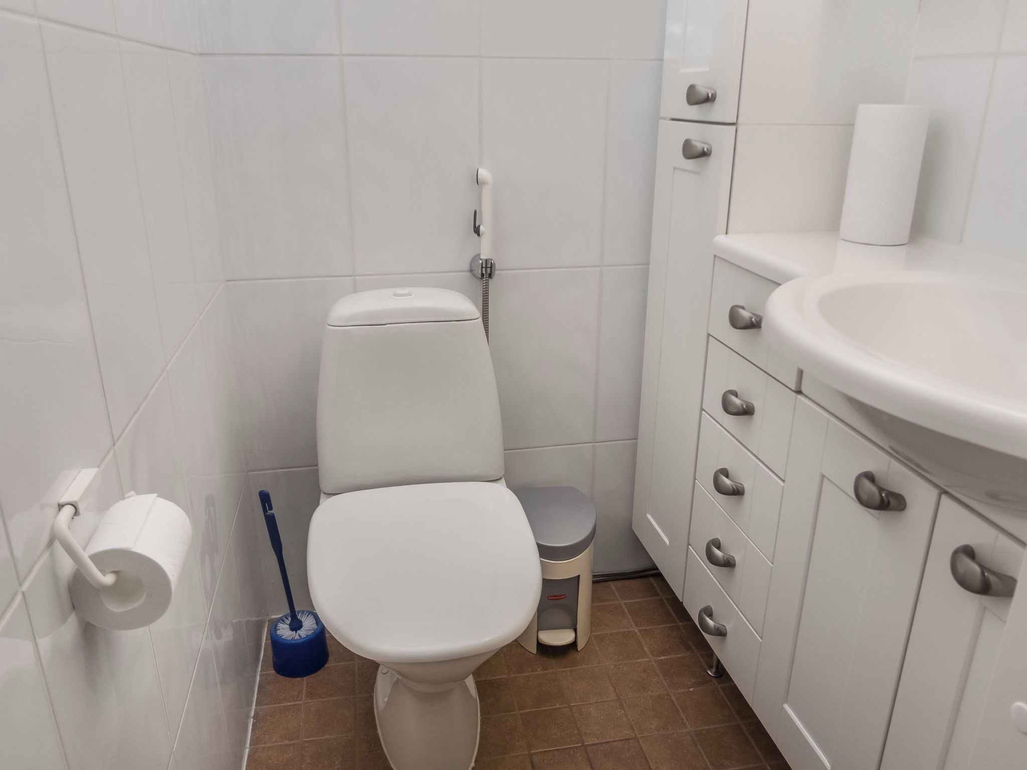 Kylpyhuone, jossa on wc, bidee, pesuallas ja wc-paperiteline.