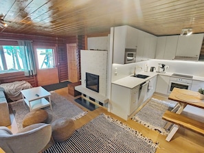 A modern kitchen with white cabinetry, a built-in oven, and a coffee maker. - Koivula by Interhome (Soini)