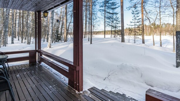 A wooden deck with benches overlooking a snowy landscape and a forest. - Vacation home 2234 by Interhome (Savonlinna)