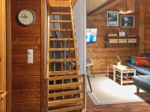A wooden interior with a ladder, a clock, a television, and a sofa. - Joutsen a by Interhome (Kuusamo)