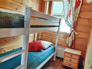 A bunk bed room with wooden walls, a window with curtains, and a small bedside table. - Joutsen a by Interhome (Kuusamo)