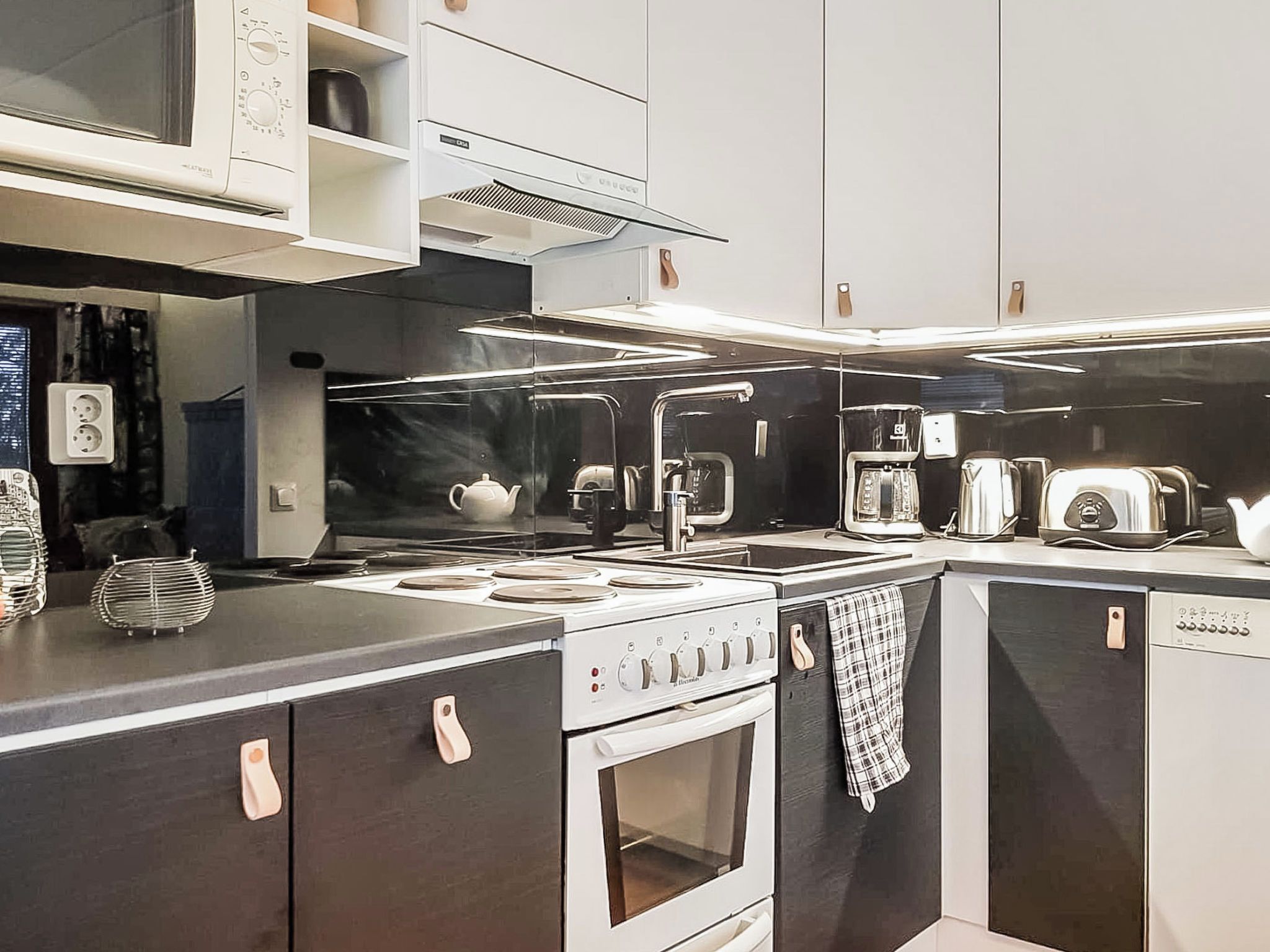 A modern kitchen with a stove, microwave, and toaster.