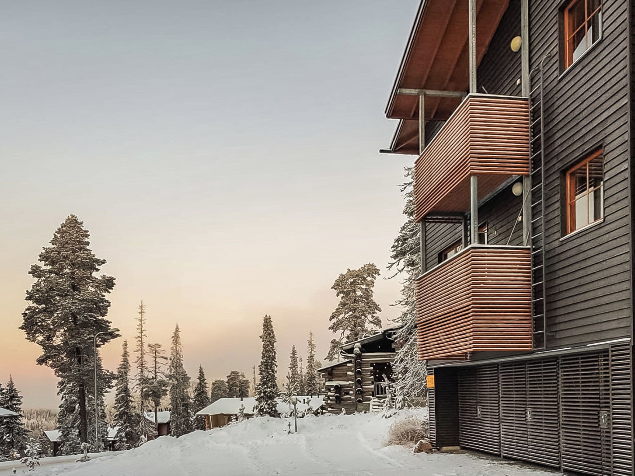 Un immeuble à plusieurs étages, doté d’une façade en bois et d’un balcon situé à l’étage supérieur.