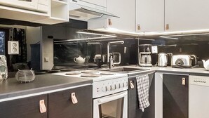 Una cocina moderna con estufa, horno, microondas y varios electrodomésticos.