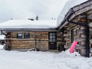 A log cabin with a snow-covered roof, a door, and a window. - Hopukka a2 by Interhome (Sodankylä)