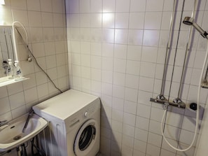 A compact bathroom with a washing machine, a sink, and a shower. - Hopukka a2 by Interhome (Sodankylä)