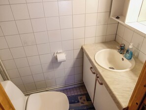 Ein Badezimmer mit Toilette, Waschbecken und Duschbereich.
