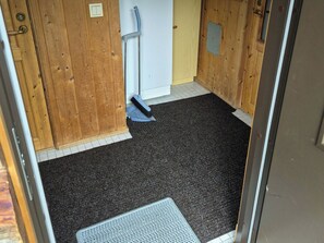 A room with wooden walls, a white door, a black carpet, and a metal doormat. - Hopukka a2 by Interhome (Sodankylä)