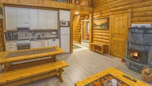 A log cabin interior with a kitchen, dining area, and fireplace. - Kaukonraitti 4 c 2 by Interhome (Kuusamo)