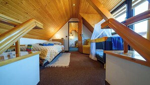 A cozy attic bedroom with a sloped ceiling, a bed, a desk, and a window. - Chalet Lucie - Four Bedroom Villa, Sleeps 10 (Mnetěš)
