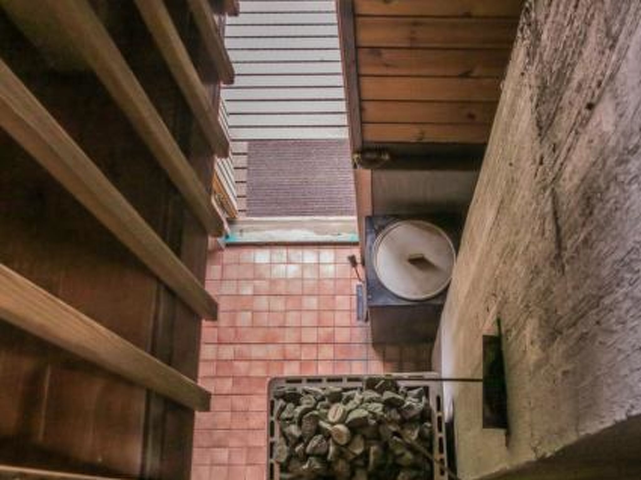 A narrow corridor with wooden walls and a tiled floor.