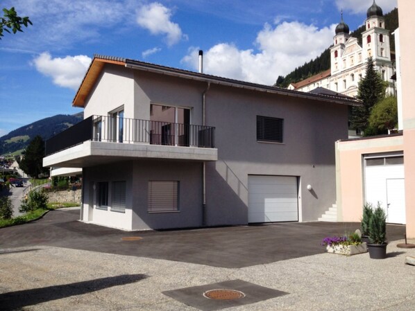 Un bâtiment à deux étages doté d’un balcon, d’un garage et d’une allée.