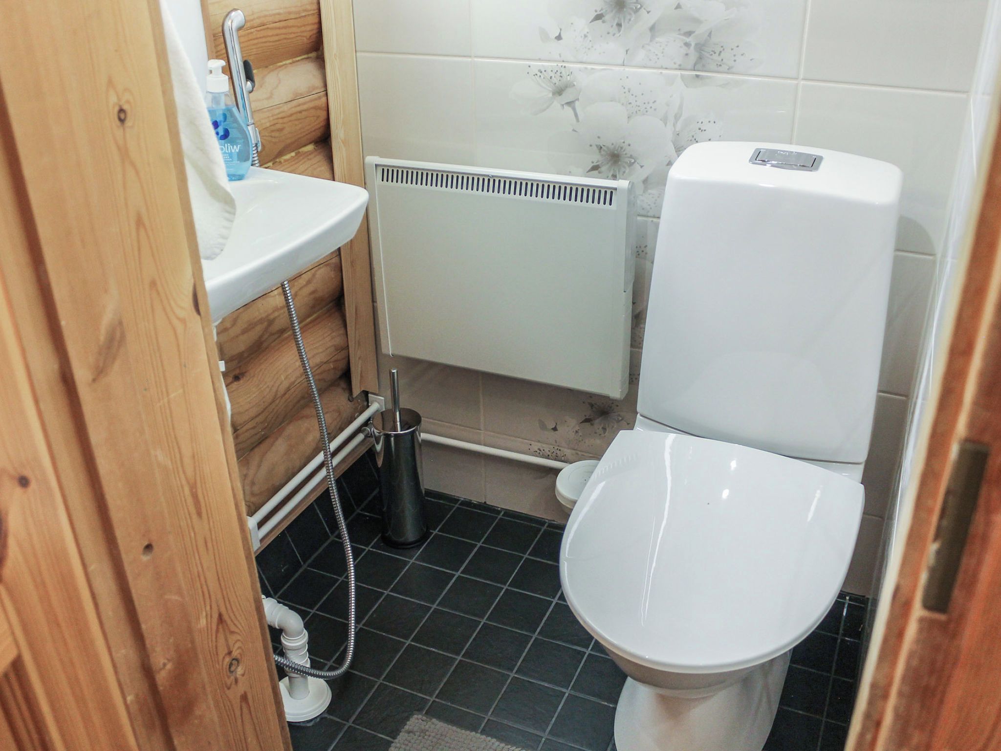 A compact bathroom with a white toilet, a sink, and a shower area.