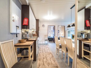 Una cocina moderna con armarios de madera, un comedor con sillas e una isla de cocina.