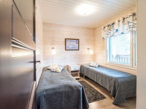 Una habitación con dos camas, un escritorio y una ventana con cortinas.
