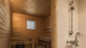 Ein Holzbadezimmer mit Fenster, Sitzbank und Dusche.