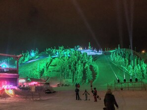 Un complejo de esquí de noche con telesillas e impianto aéreo iluminados.