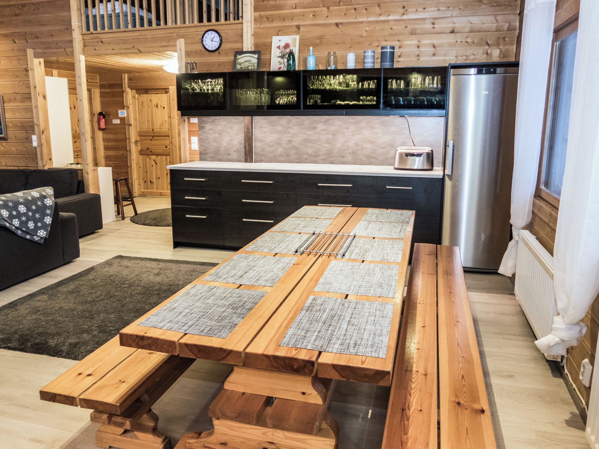 Una cocina moderna con una mesa de madera y un refrigerador empotrado.